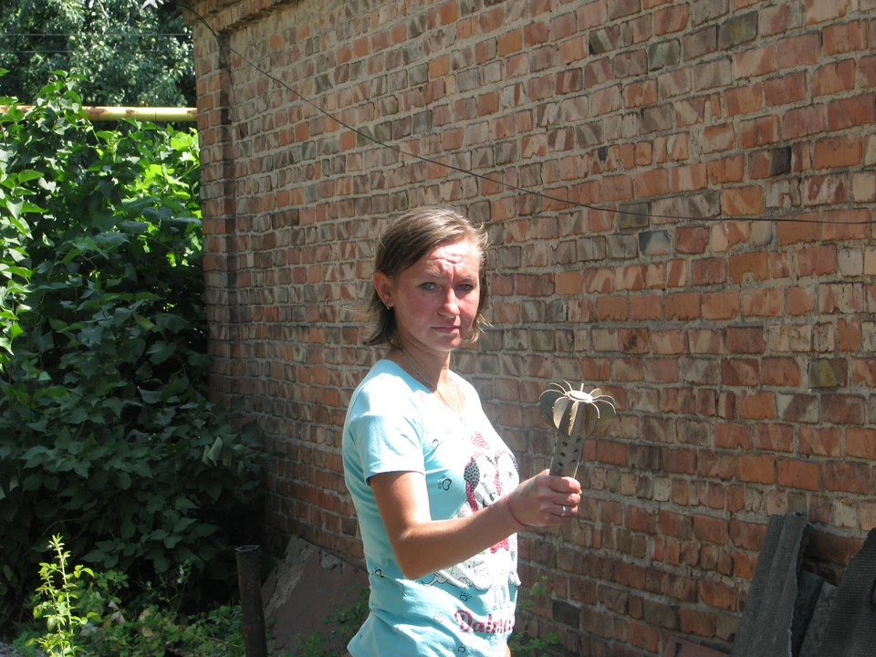 Ирина Лябах показывает американскую мину, стесавшую угол ее дома.
