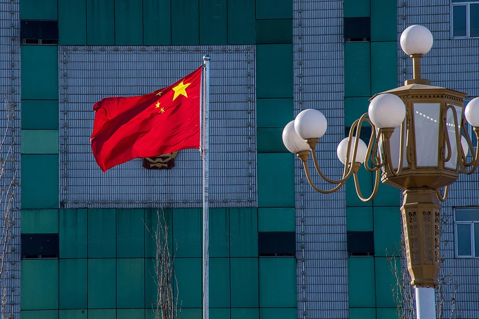 Китайский флаг на фоне одного из современных деловых зданий в Хэйхэ.