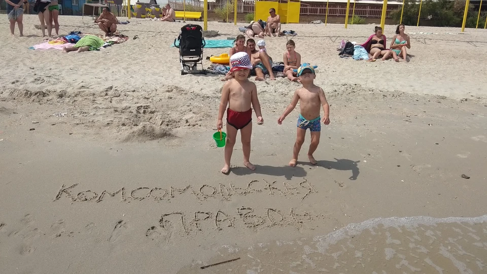 Детишки нравится возиться в песке на берегу пляжа