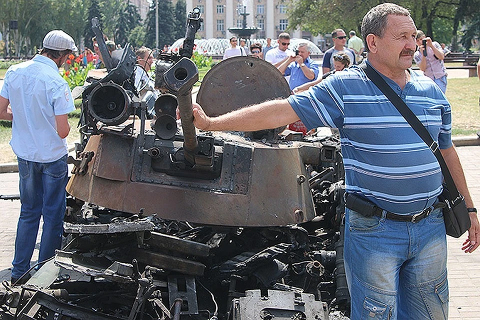 Жители Донбасса на фоне уничтоженной украинской военной техники.