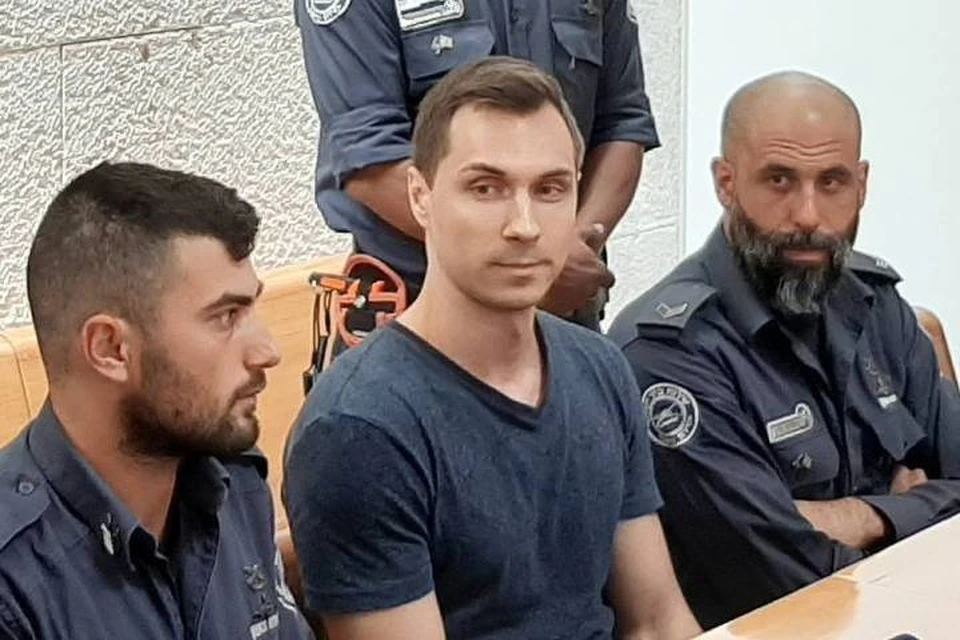 Россиянин Алексей Бурков в окружении израильских правоохранителей. Фото: Андрей Широков/ТАСС