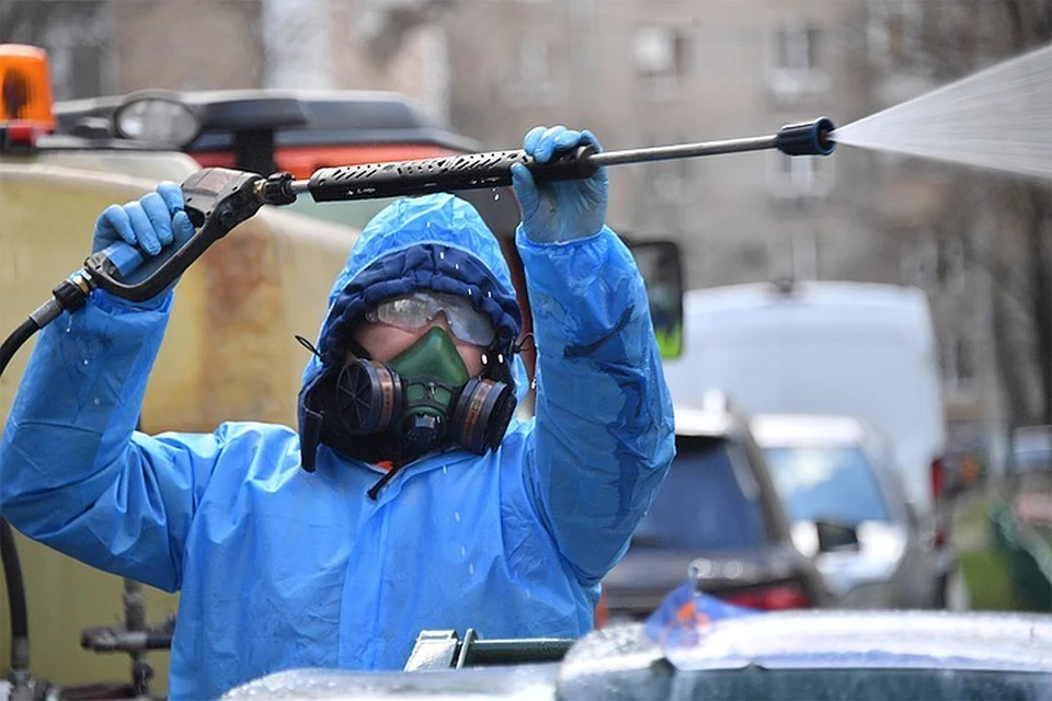 Москва. Сотрудник коммунальной службы в защитном костюме во время дезинфекции улиц.