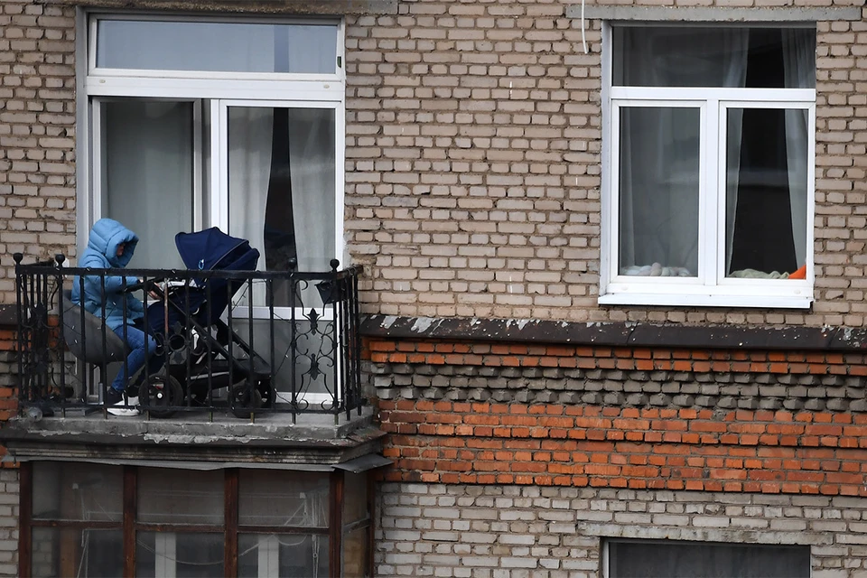 Москва. Женщина с коляской на балконе в дни режима самоизоляции.