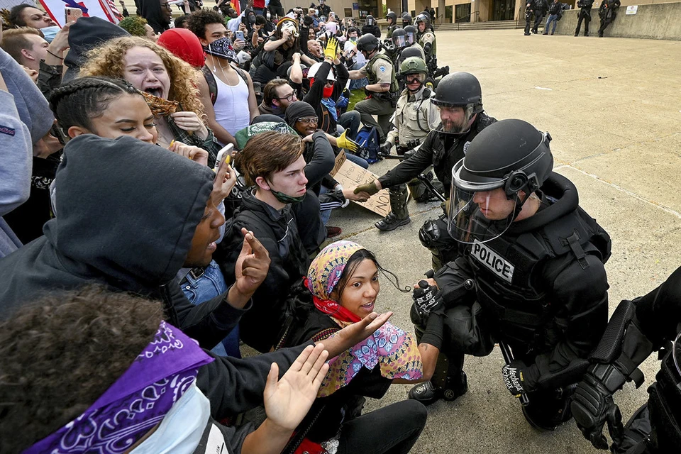 Полицейские опустились на одно колено перед разгневанной толпой молодежи в городе Спокан, штат Вашингтон, США.