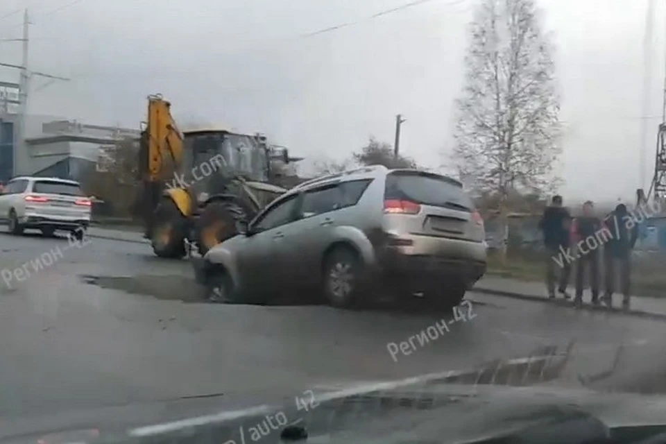 Автомобиль провалился в яму на дороге в центре Кемерова. ФОТО: кадр видео vk.com, "Регион 42"