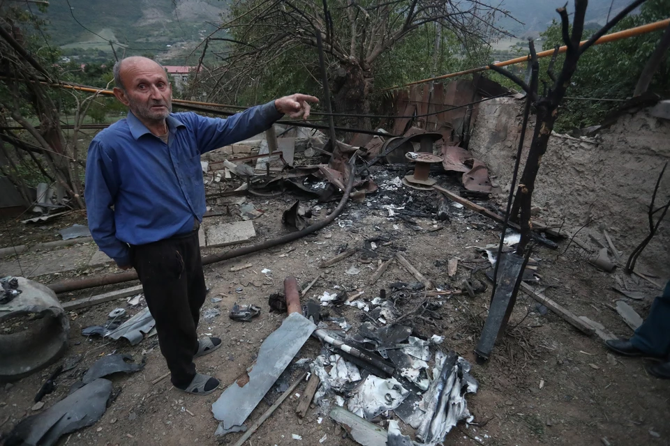 Житель города Гадрут показывает на разрушения после обстрела.
