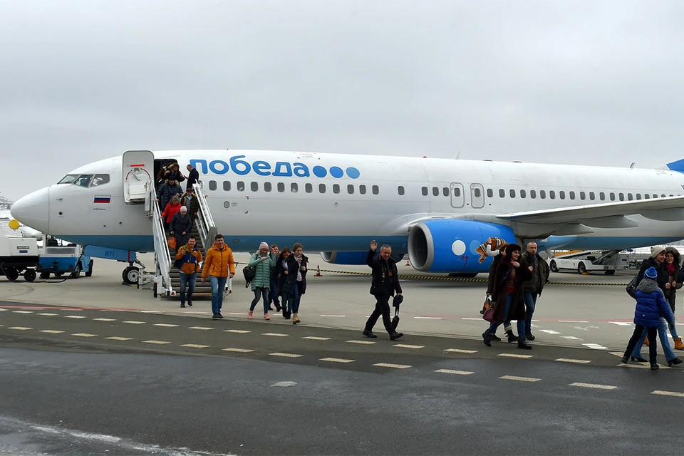 Пассажиры самолета авиакомпании "Победа" покидают борт после приземления.