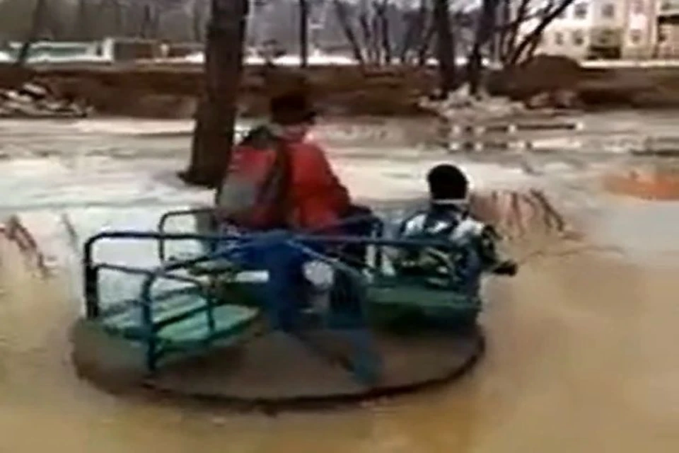 Дети катаются на затопленной карусели в одном из дворов Ярославля. Фото: "Жесть Ярославль"
