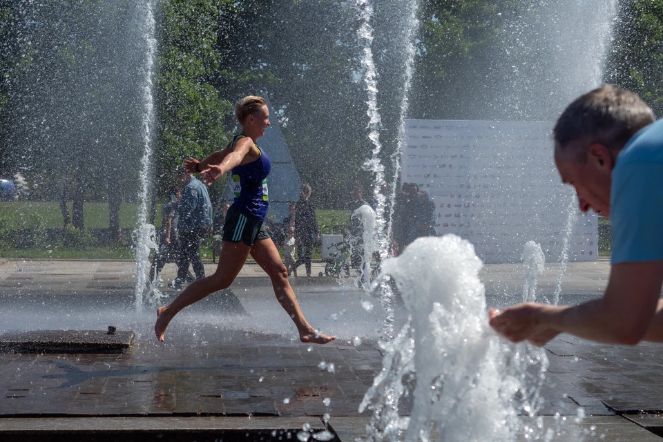 Петербуржцы спасаются от жары в фонтане парка 300-летия.