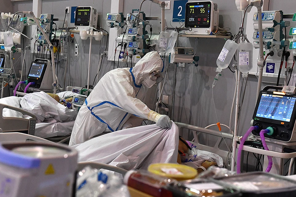 Врач укрывает одеялом пациента резервного госпиталя для больных ковидом в отделении ГКБ №24 на ВДНХ.