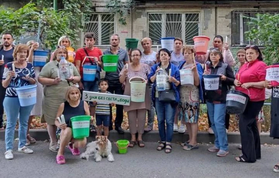 Люди с пустыми ведрами в руках выстроились вдоль своего дома. Фото: группа жильцов дома в соцсетях