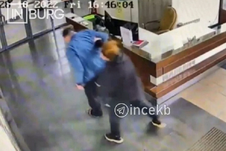 Женщина била охранника в спину, когда шла по холлу ЖК. Фото: скриншот видео