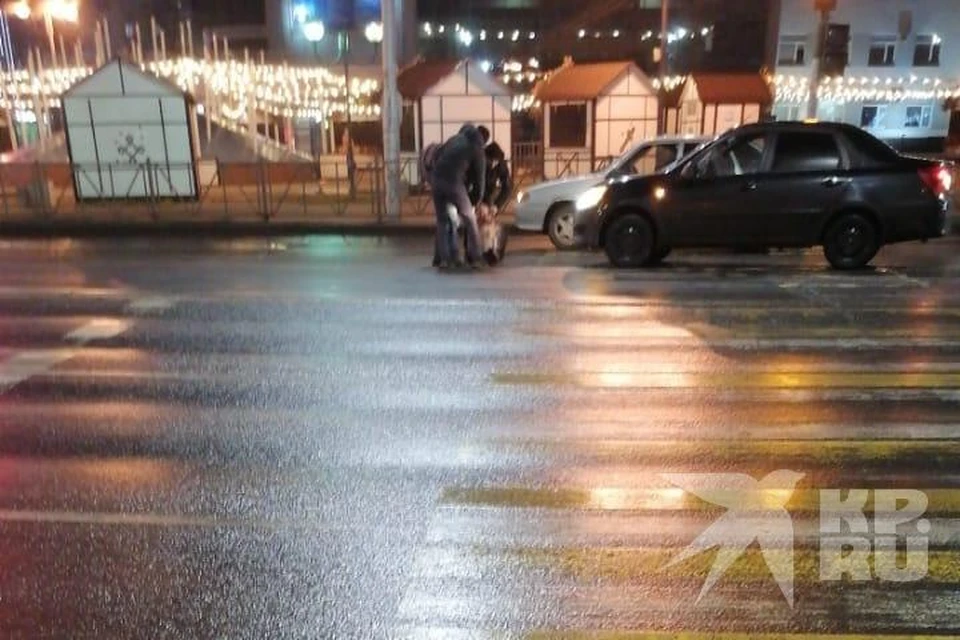 Из-за неработающих светофоров на пл. Победы в центре Рязани «Лада» сбила человека. Двое мужчин оттаскивают пострадавшего с дороги.