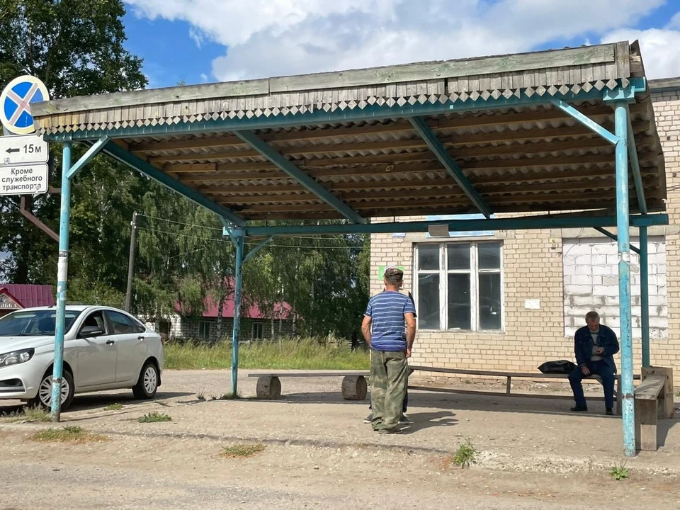 Костромичи ждут автобусов под маленьким навесом. Сзади - бывшее здание автостанции, теперь там магазин.