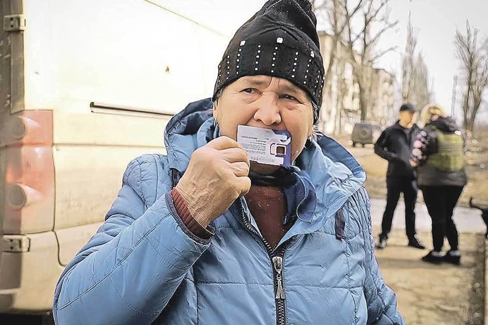 Жительница Авдеевки буквально поцеловав российскую сим-карту, теперь она сможет позвонить близким и сообщить, что жива. Фото: Народный фронт ДНР