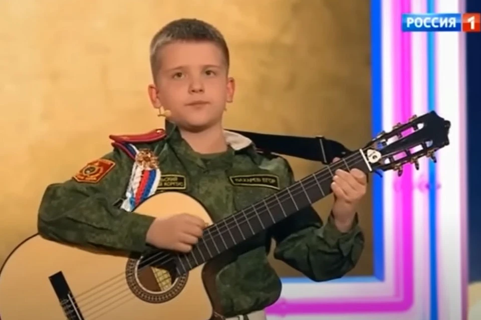 Мальчик под гитару исполнил композицию «От героев былых времен». Скриншот видео программы «Песни от всей души» на телеканале «Россия - 1»