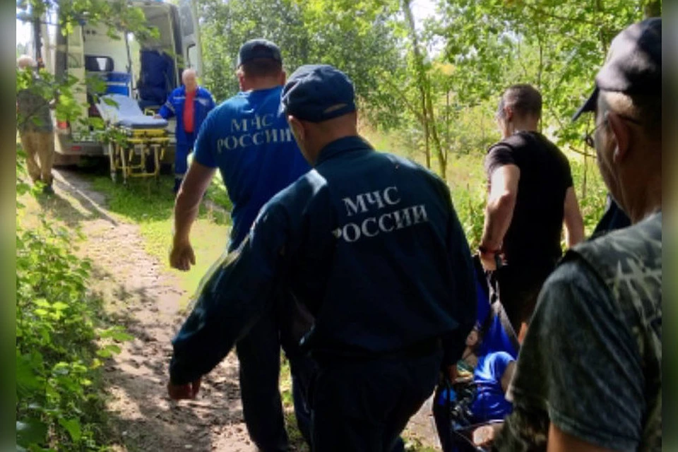 Спасатели донесли женщину до кареты скорой помощи. Фото: МЧС