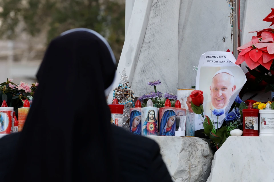 Десятки людей продолжают молиться о его здоровье, они оставляют свечи и цветы возле больницы.