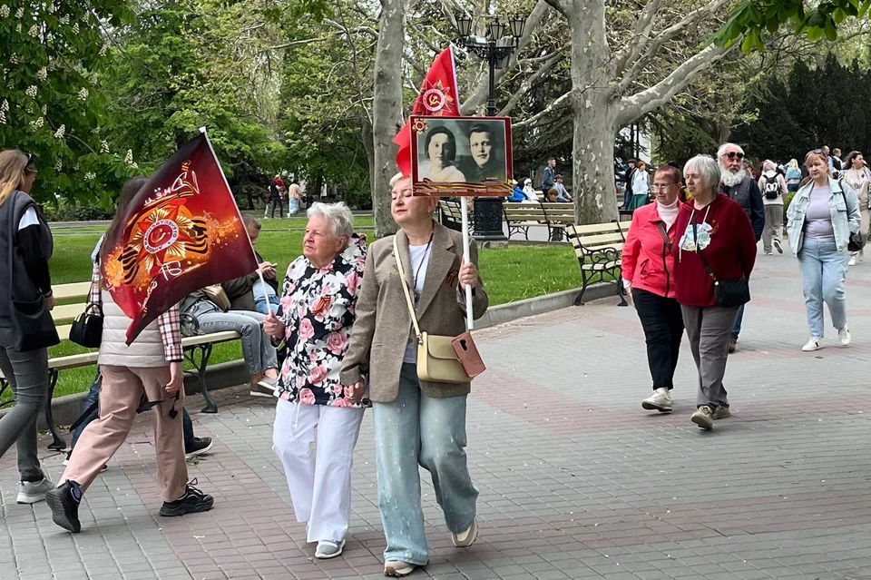Севастопольцы гуляли с флагами и портретами родных-героев.