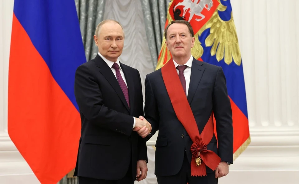 Владимир Путин поздравляет Алексея Гордеева с наградой.