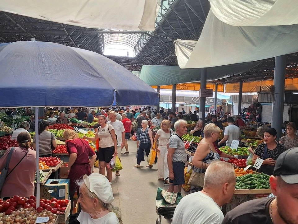 Продавцы уверяют, что жара отпугнула покупателей, хотя людей на рынке много.