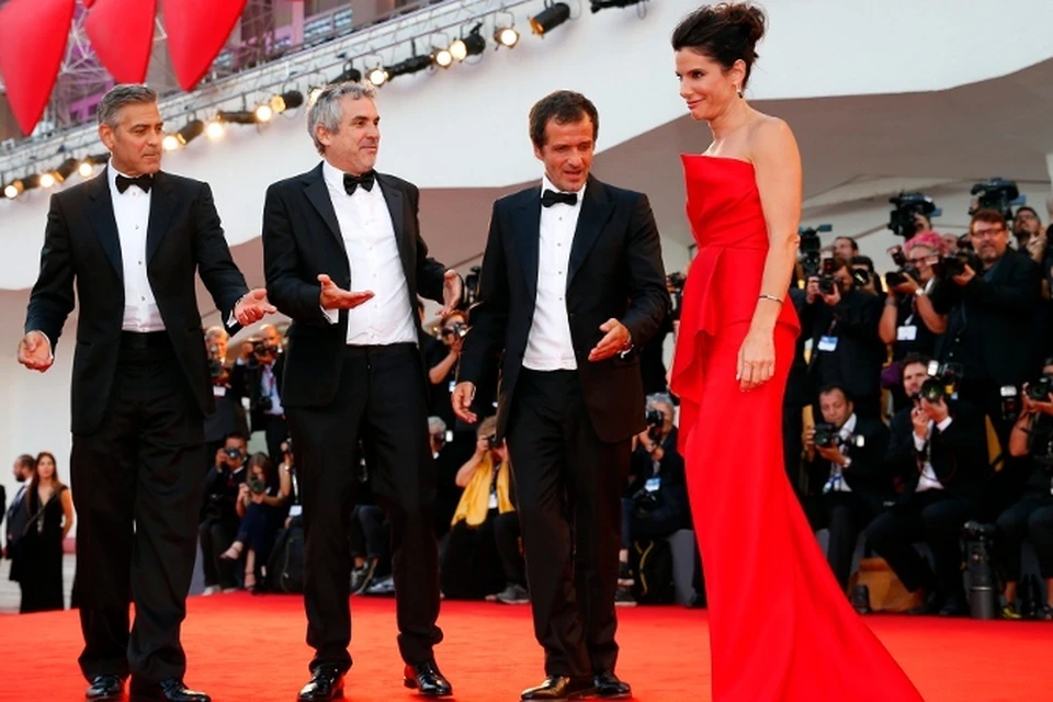 В Венеции открылся кинофестиваль/ На красной дорожке: актер Джордж Клуни, режиссер Альфонсо Куарон, продюсер Дэвид Хейман приветствуют Сандру Буллок