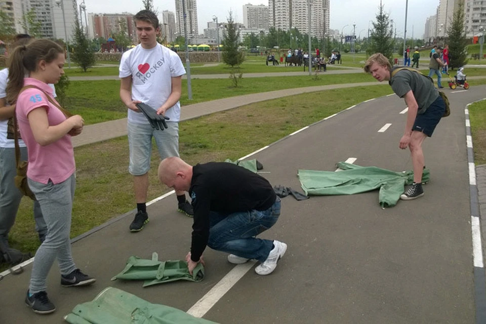 Школьники тренируются складывать костюм химзащиты.