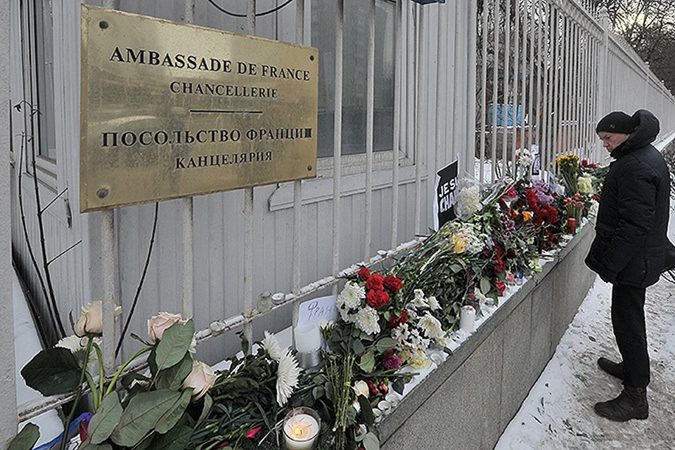 Москвичи несут цветы и зажигают свечи у посольства Франции