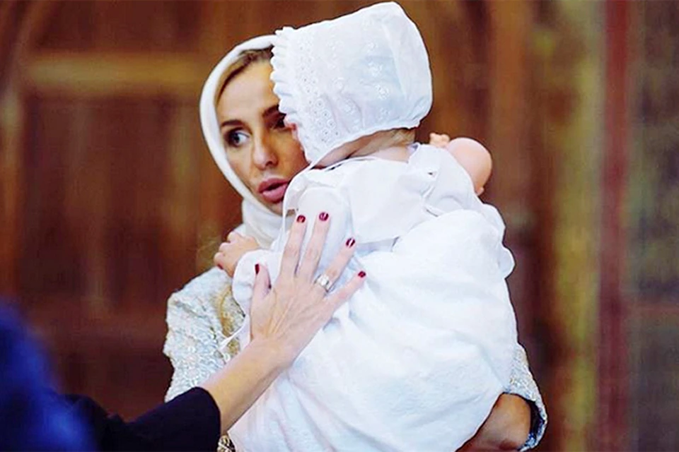 На фото Татьяна в косынке прижимает к себе крошку-дочь в белоснежном платице
