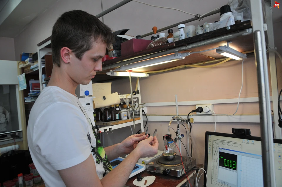 В руках у Дениса Дьяченко титановая пластинка и графит. Сейчас их отправят в электролит.