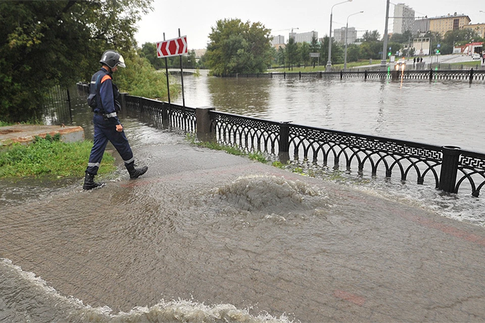 15 августа 2016 г. Сотрудник МЧС на затопленной набережной Москвы.