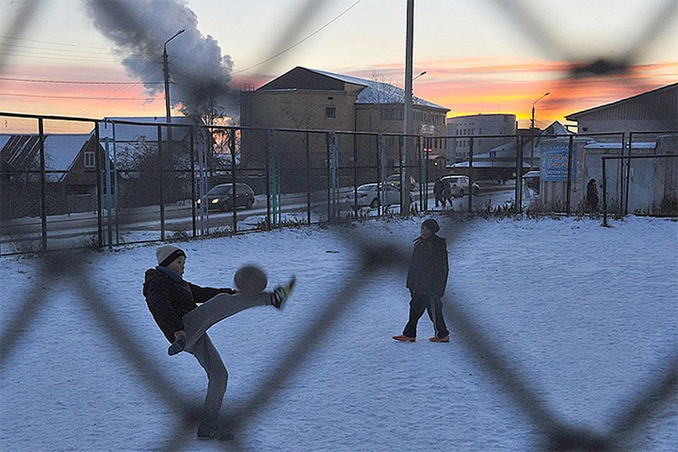 Зима в разгаре. Мальчишки пинают футбольный мяч на улицах вечернего Улан-Удэ.